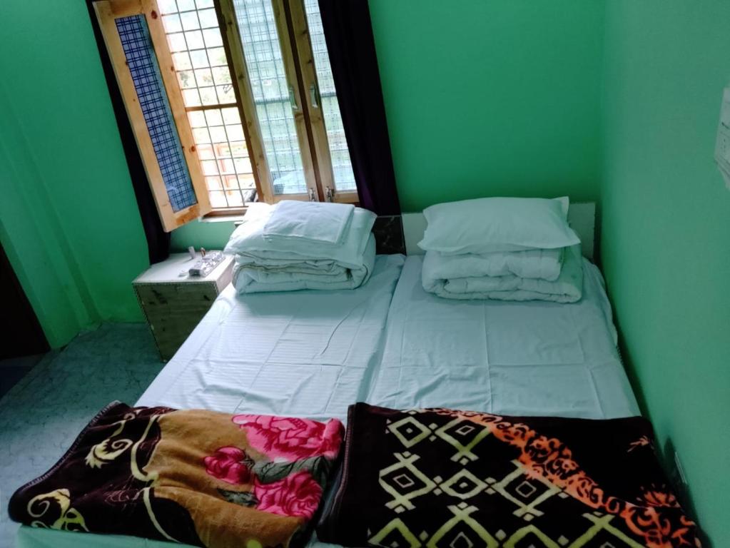 乔斯希马特Shivashram的配有2扇窗户的客房内的1张床