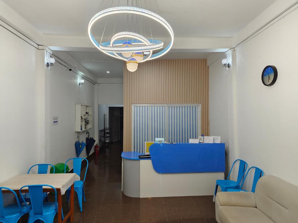 万象Ocean Blue Hostel Vientiane的一间设有蓝色椅子和吊灯的等候室