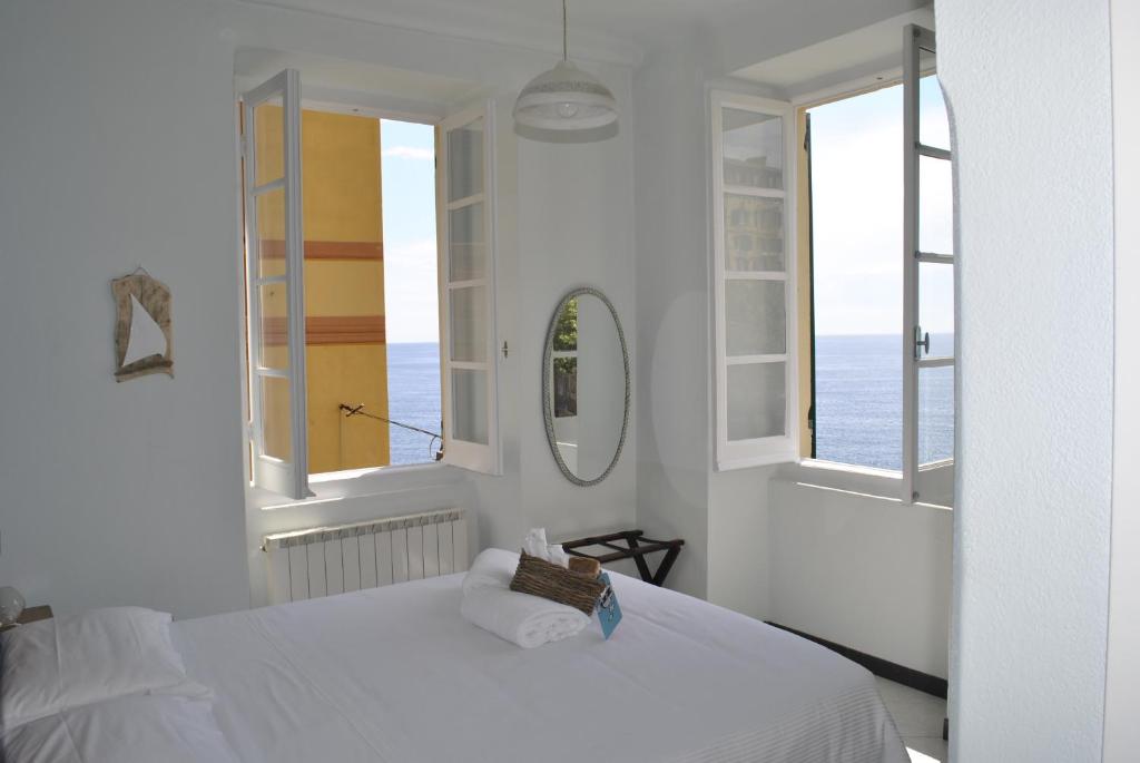 卡莫利Al Piccolo Scoglio - Room & Breakfast的一间白色卧室,配有床和2个窗户