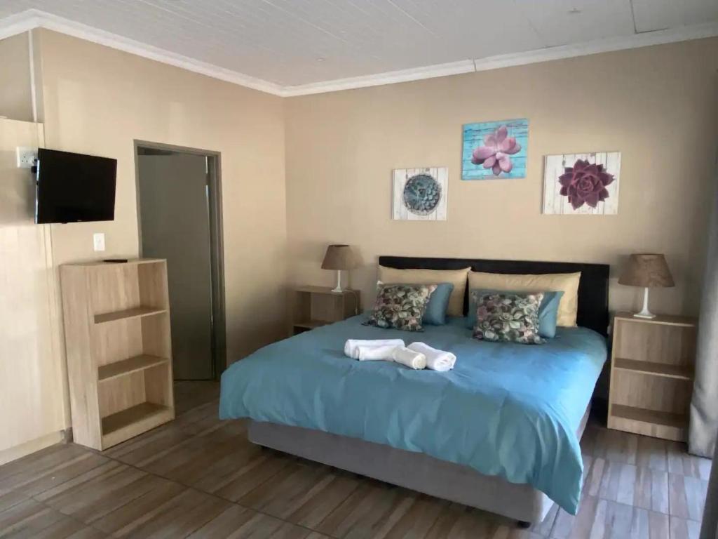 布隆方丹Aloe Guest Rooms的一间卧室配有一张床,上面有两条毛巾