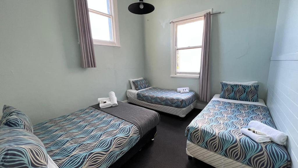 凯阿玛Beachside Budget Rooms的一间设有两张床和两把椅子的房间