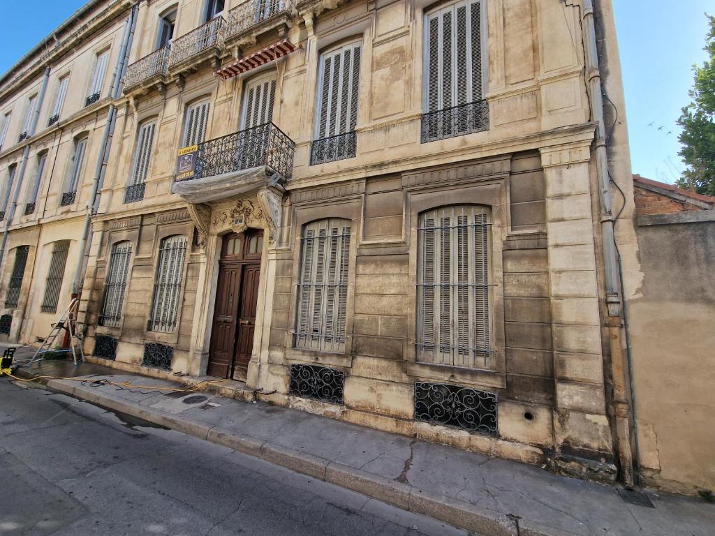 尼姆Nimes: Appartement l'Auguste Centre-Ville.的街上有窗户和门的古老建筑