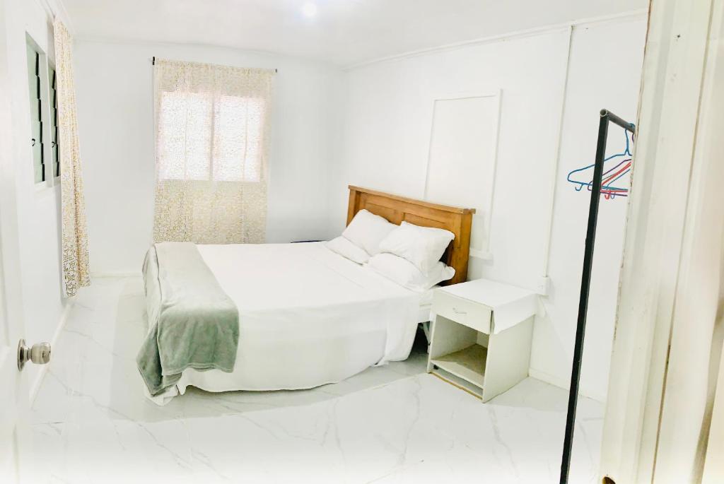 FolahaTonga Cottage - Private Double Room Shared Facility的白色的卧室设有床和窗户
