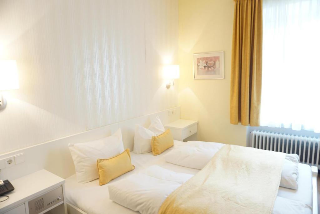 帕绍Herdegen Rooms - Self Check-in的酒店的客房 - 带白色床和黄色枕头
