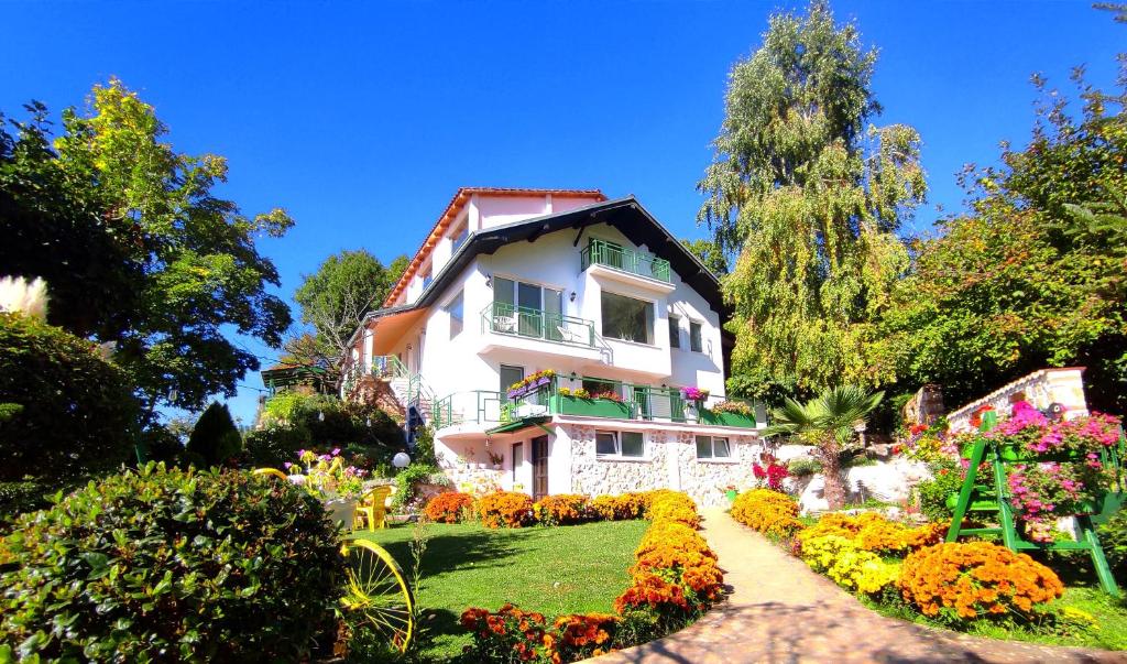 奥赫里德Villa Forest Paradise的前面有花园的白色房子
