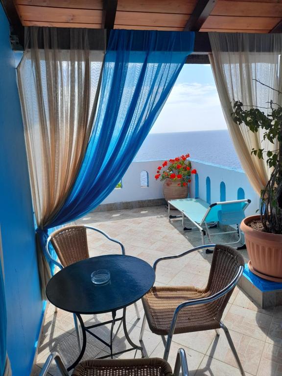 AkhladheríDelfini的阳台配有桌椅,享有海景。