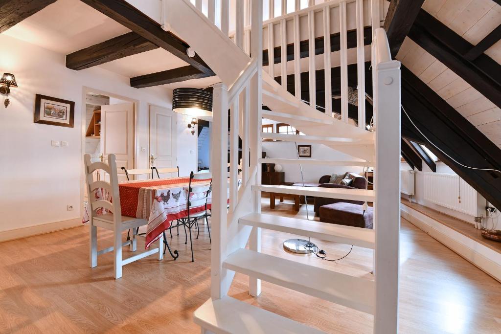 希伯维列Au Nid d'Hirondelles的一间厨房和带白色螺旋楼梯的用餐室