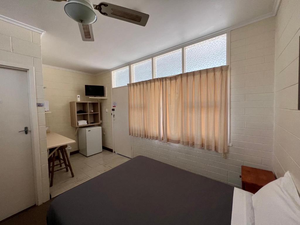 WinkieGlossop Motel的客房设有一张床和一个带书桌的窗户