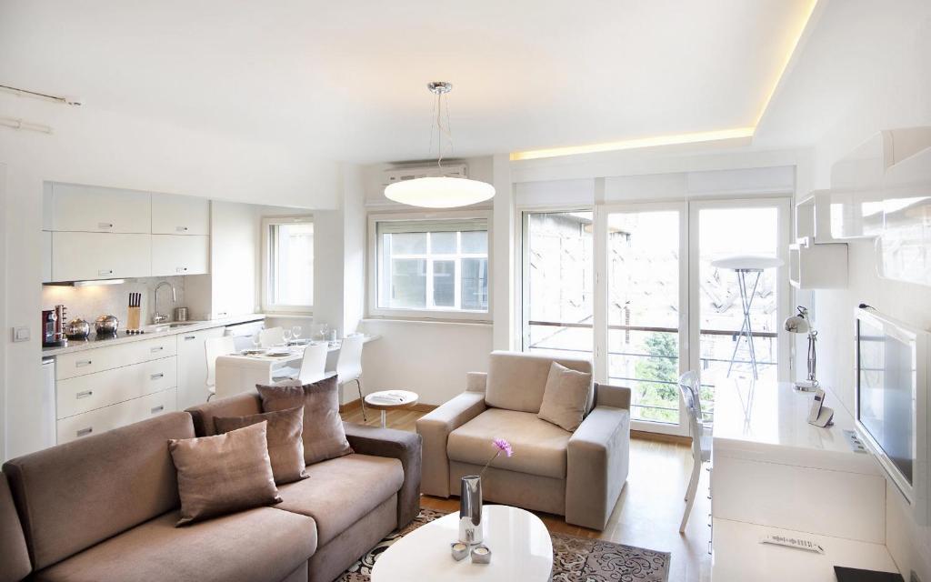伊斯坦布尔努鲁子​​牙套房酒店的带沙发和椅子的客厅以及厨房。