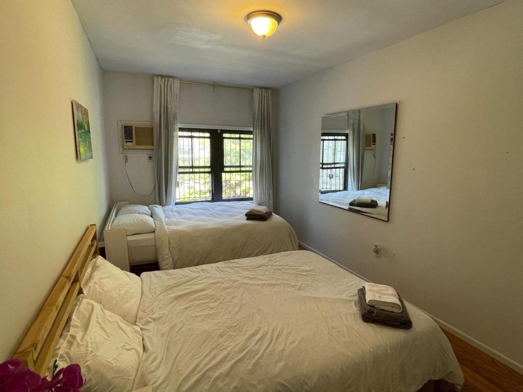 布鲁克林Spacious Bedroom for 4 in shared Townhouse+garden的一间卧室配有两张床和镜子