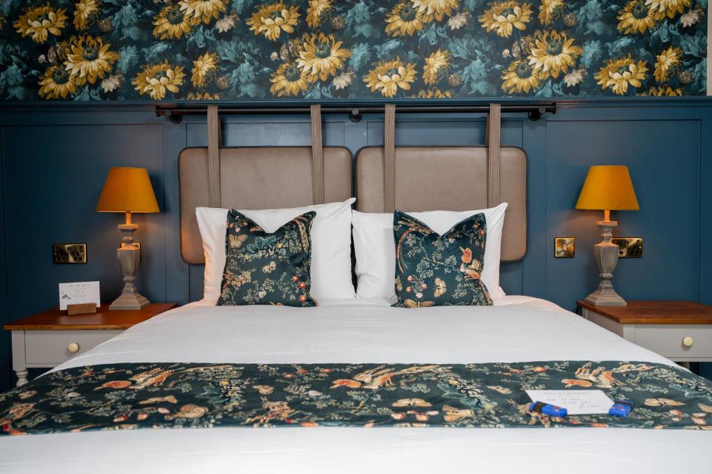 格拉茨克洛斯Ethorpe Hotel by Chef & Brewer Collection的一间卧室配有一张带蓝色墙壁的大床