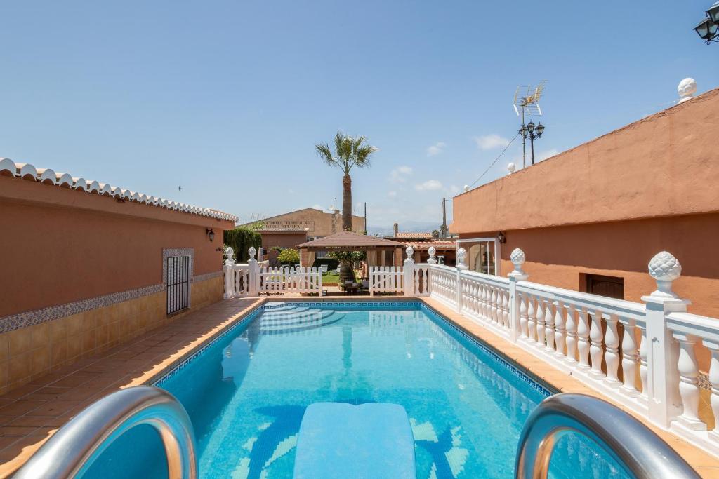 莫特里尔Villa Torres Motril的一个带白色栏杆围栏的游泳池和别墅