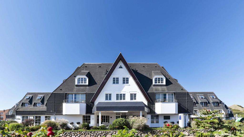 韦斯特兰多林特海滩度假村及威斯特兰/叙尔特Spa中心的黑色屋顶的大型白色房屋