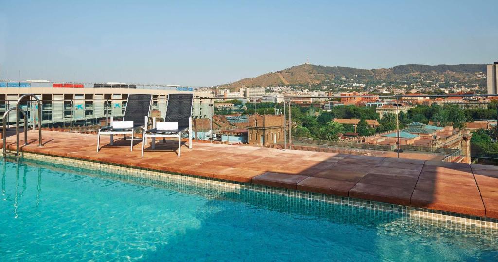 巴塞罗那NH巴塞罗那体育场酒店的建筑物屋顶上的游泳池