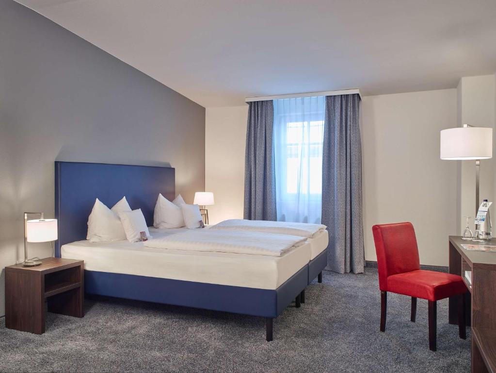 弗洛托B&K Hotels的酒店客房,配有一张床和一张红色椅子