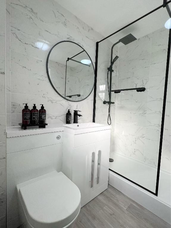 伦敦Stunning Newly Decorated Flat with Private Entrance的白色的浴室设有卫生间和淋浴。