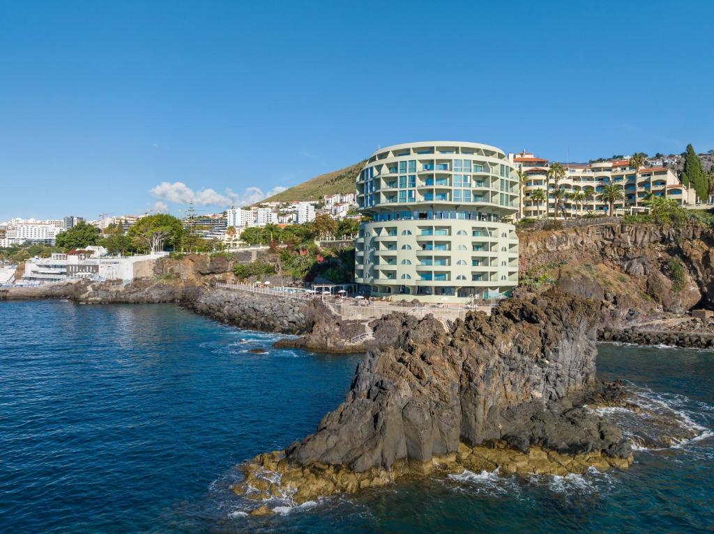 丰沙尔Pestana Vila Lido Madeira Ocean Hotel的海边悬崖上的建筑