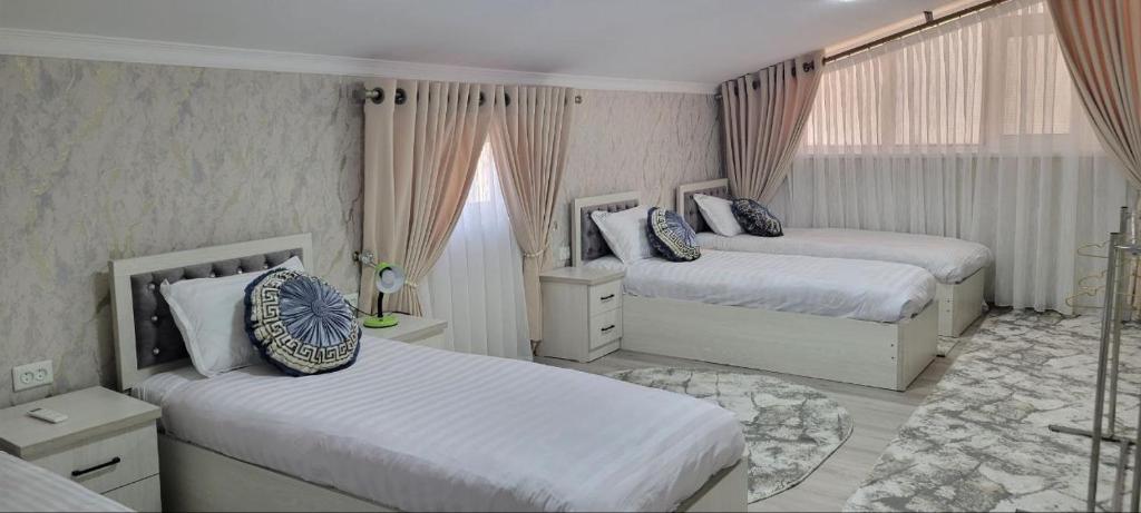 撒马尔罕Imran&Bek的一间带两张床的卧室和一间带两扇窗户的房间