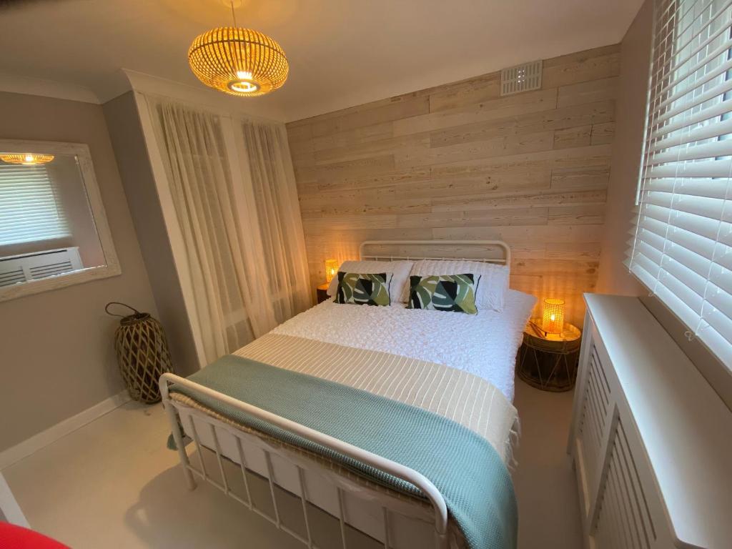 托特兰Leeward Lodge的一间卧室配有一张木墙床