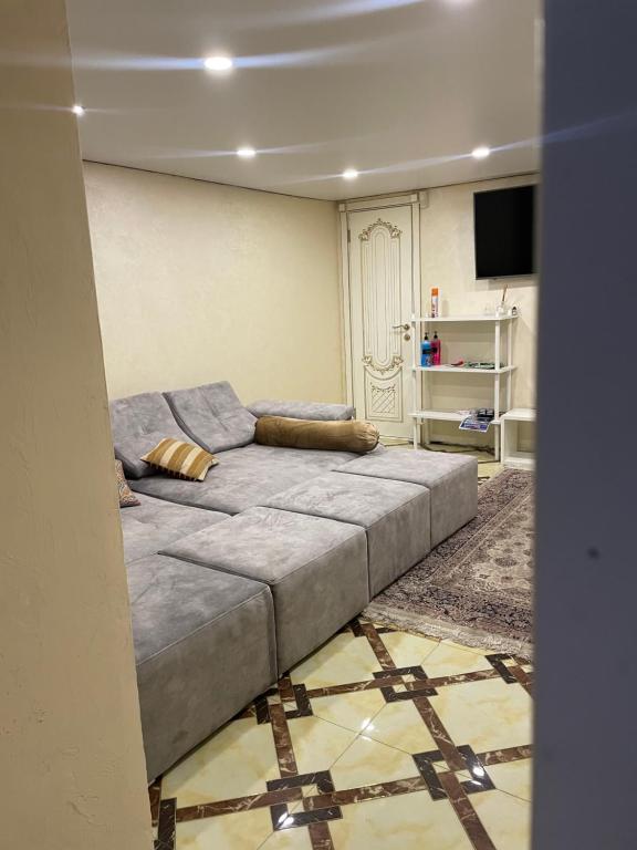 Kok-ShokyLa Villa的一间配有电视的房间里一张大灰色的沙发