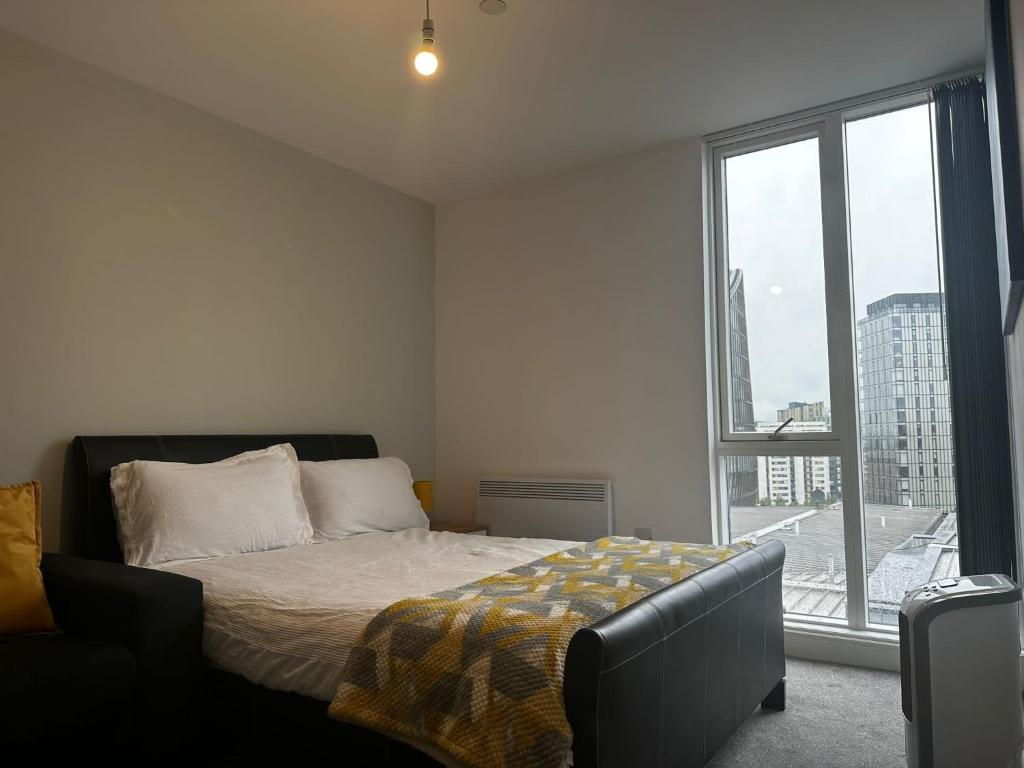 曼彻斯特At home Property的一间卧室设有一张床和一个大窗户