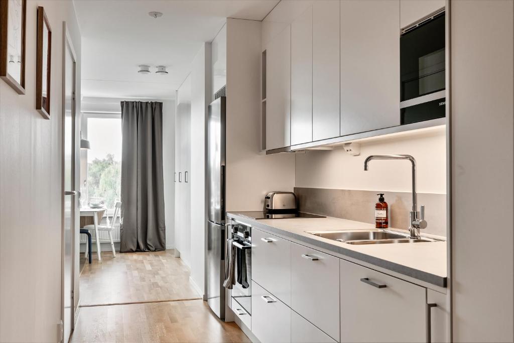 斯德哥尔摩Cosy Urban Home in Stockholm的厨房配有白色橱柜和水槽