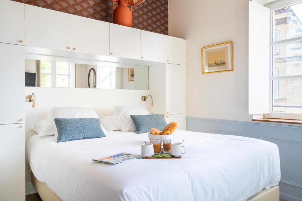 普罗旺斯地区萨隆La Réserve de Salon de Provence的卧室配有白色的床,并备有托盘