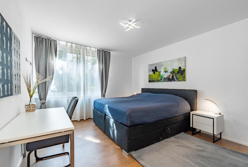 伯尔尼Möblierte Zimmer - gratis Parkplatz的一间卧室配有一张床、一张书桌和一个窗户。
