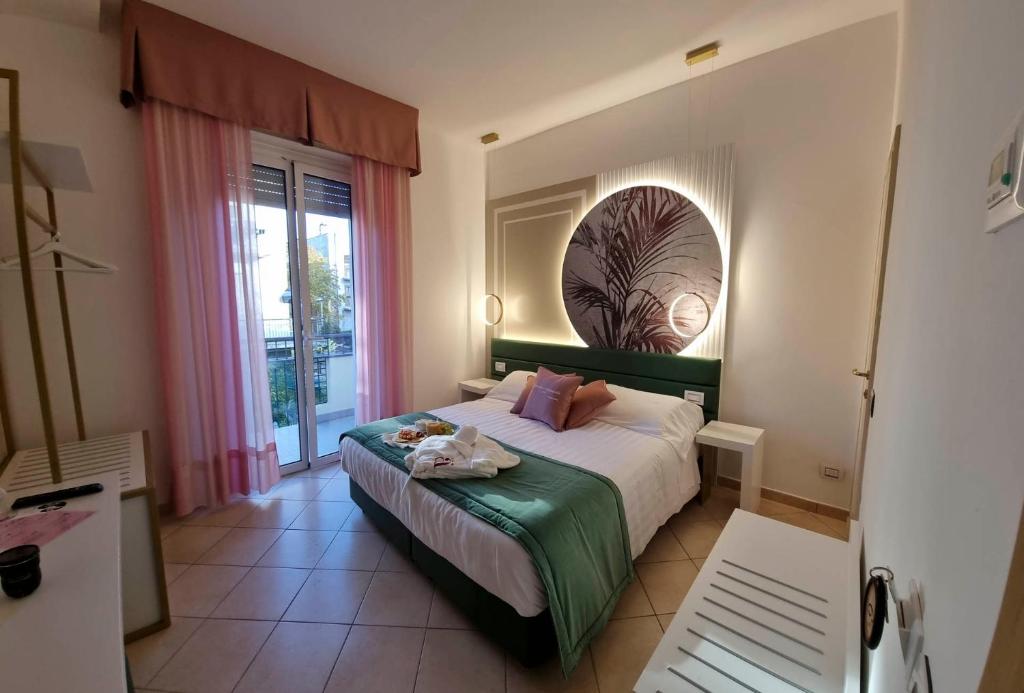 里米尼安格里尼酒店的一间卧室设有一张床和一个大窗户