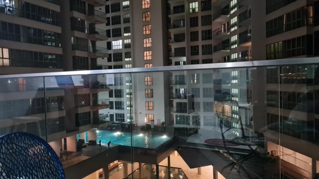 吉隆坡Regalia Sky pool Hostel @ 969的夜间从公寓大楼的阳台上欣赏风景