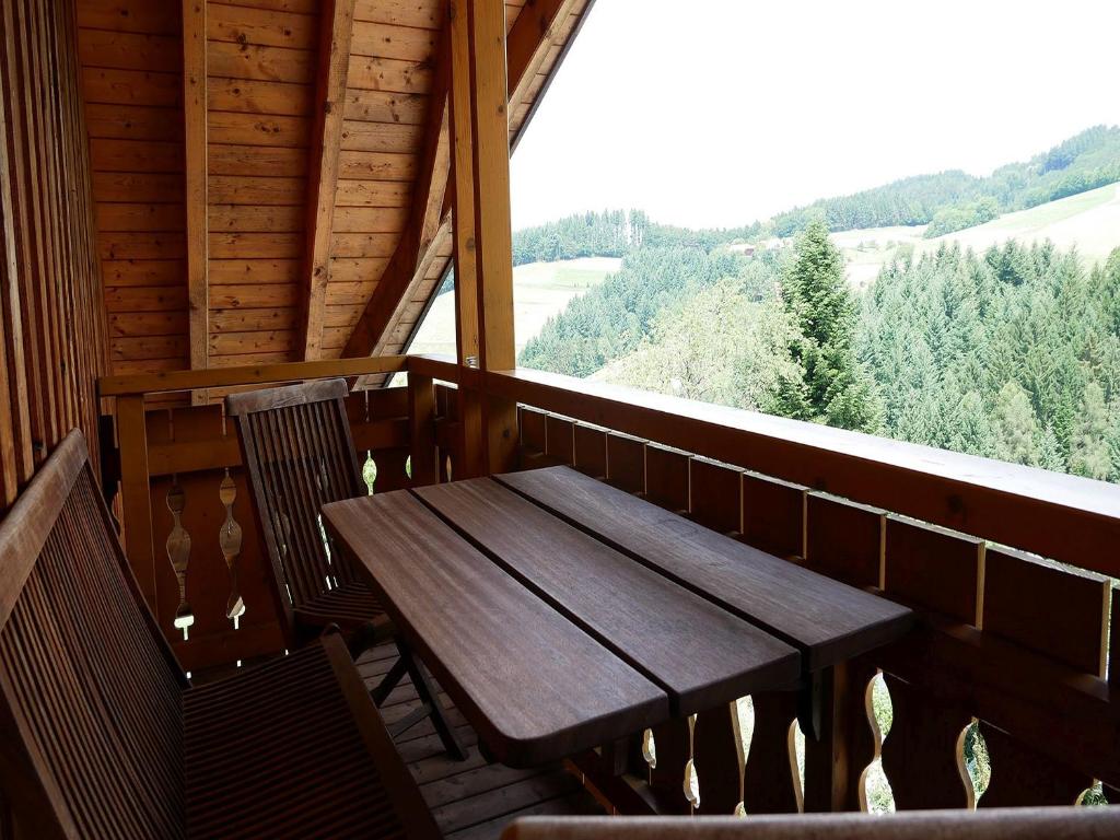 HorbenFerienwohnungen Ringlihof的小屋阳台上的一张木桌和椅子