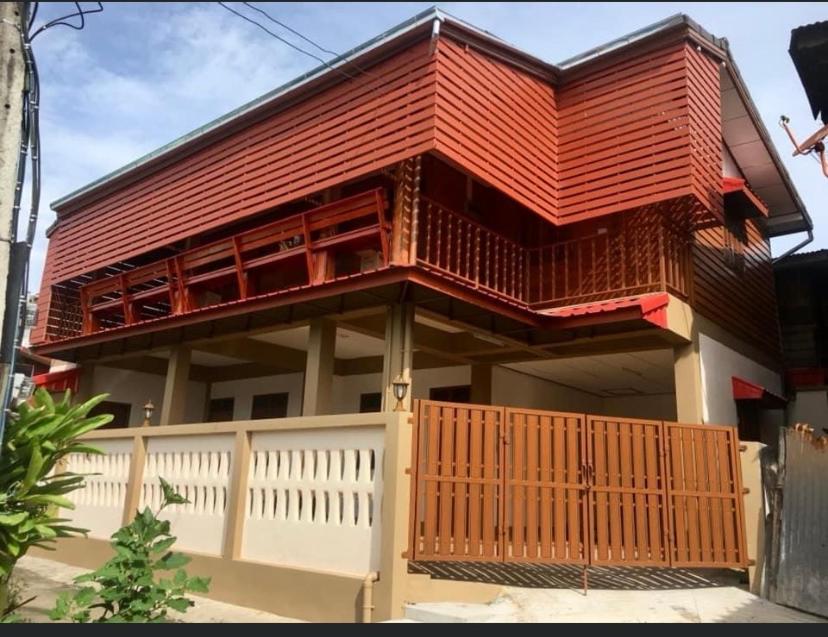 清刊Baan Fun Dee Chiang Khan的一座红色屋顶和白色围栏的房子