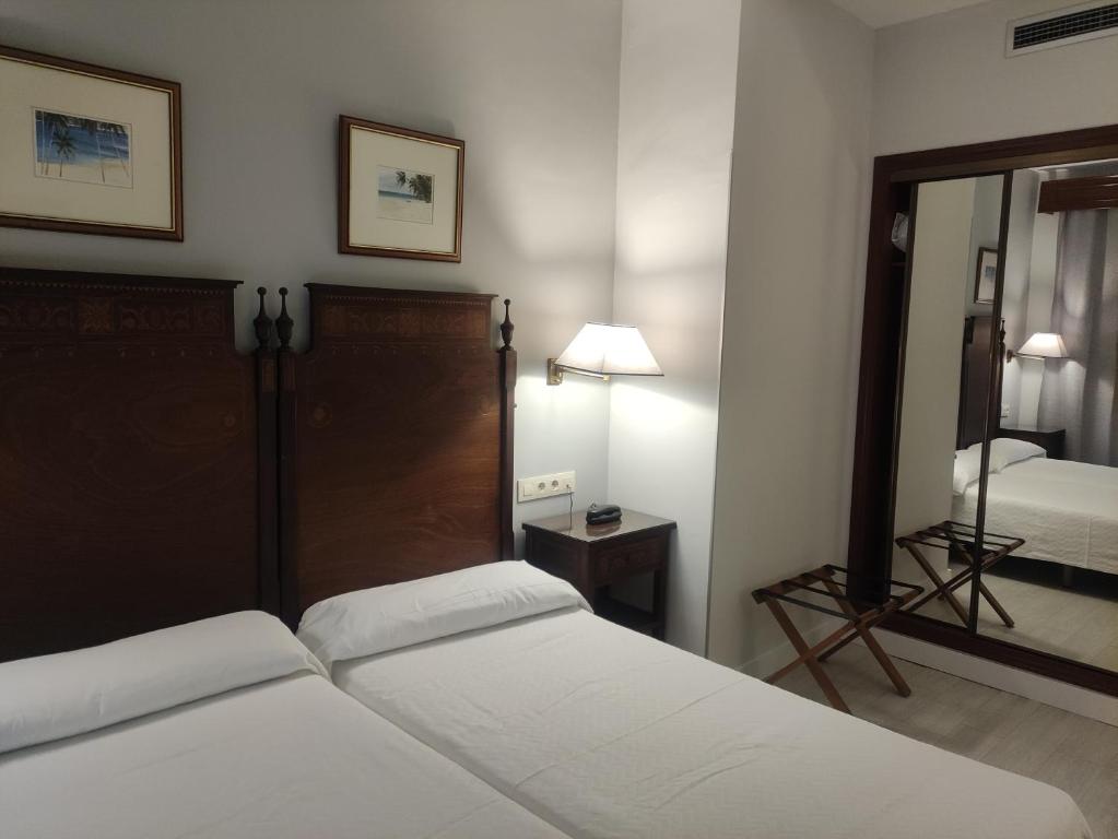 卡塞雷斯伊维萨美洲海滩酒店的酒店客房,设有两张床和镜子