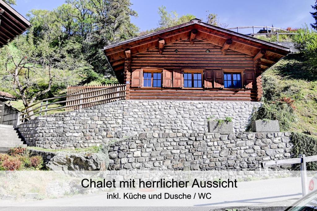 KüblisGemütliches Chalet mit schöner Aussicht的石墙上的小木屋