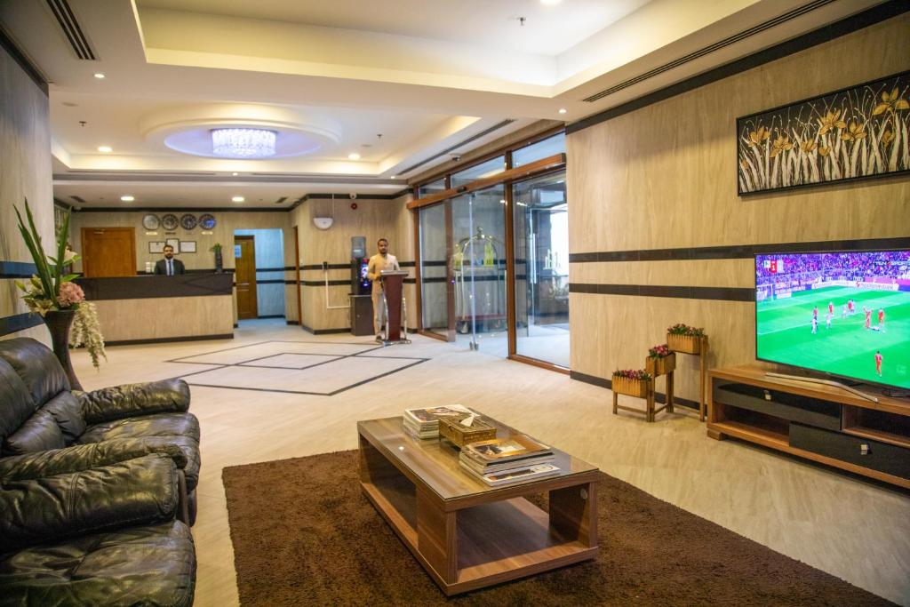 朱菲尔Juffair Trends Luxury Apartment的一间带电视和沙发的客厅