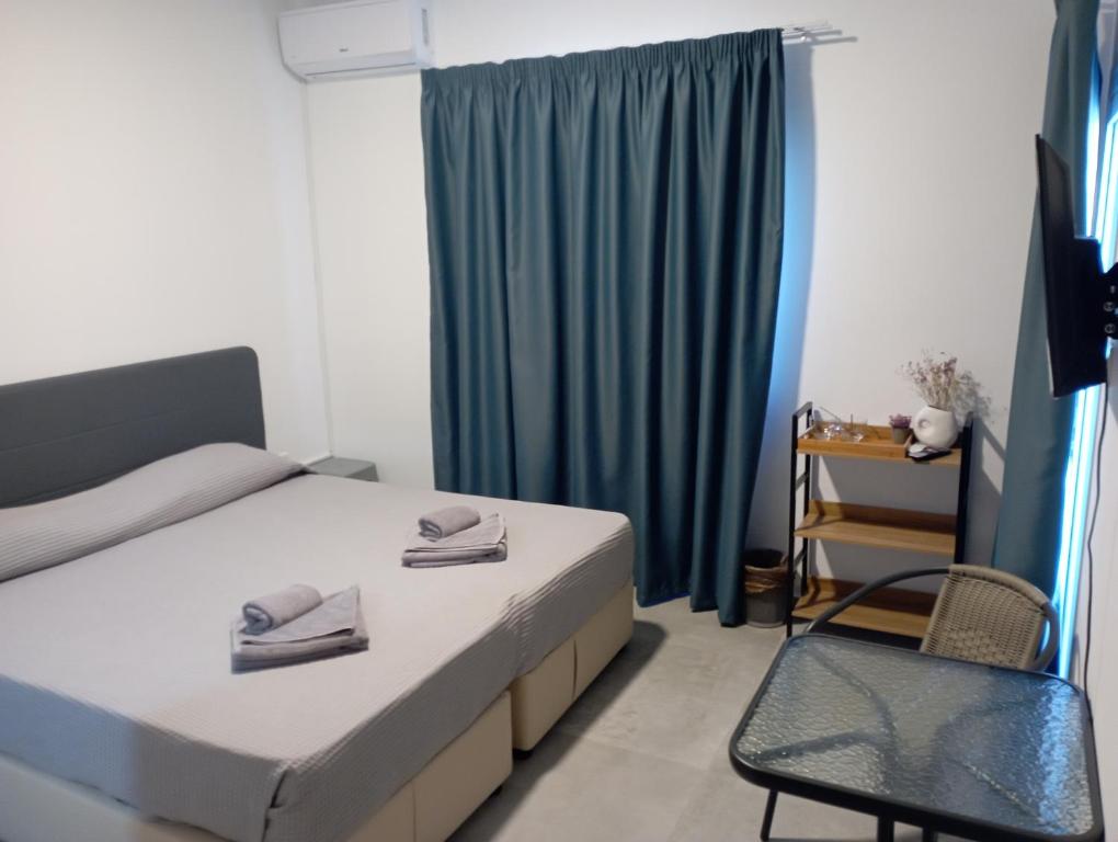 阿依纳帕BluejSuite的卧室配有床、椅子和窗户。