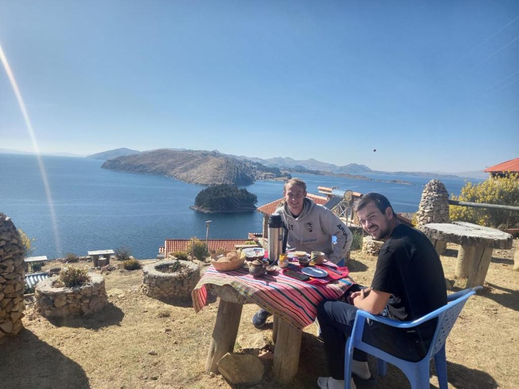 Comunidad YumaniRefugio Ecologico Kalluchi的两人坐在野餐桌上,享有海景