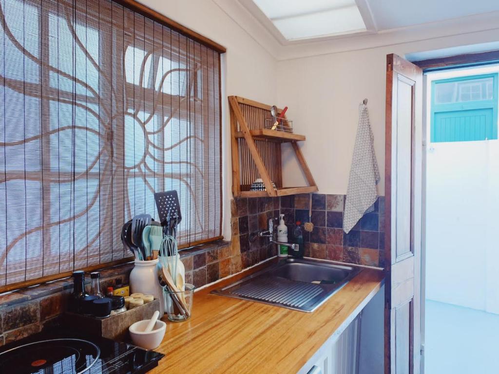 开普敦Cottage On Windsor的厨房配有柜台、水槽和窗户