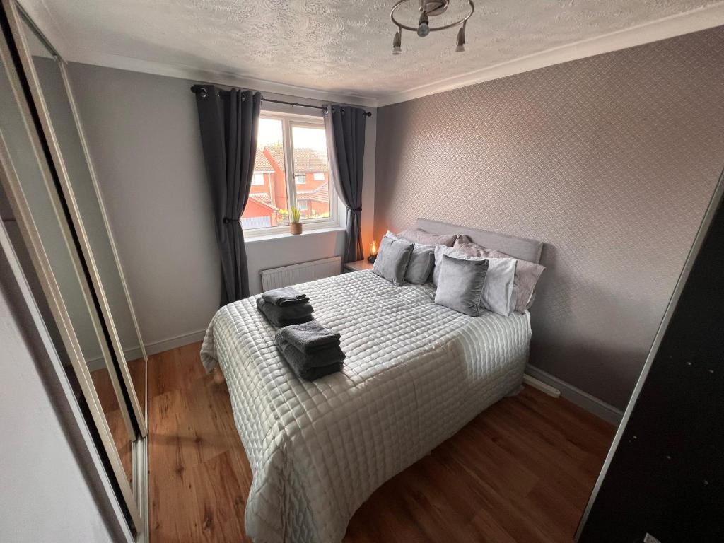 CONTRACTORS OR FAMILY HOUSE - M1 Nottingham - IKEA RETAIL PARK - CATKIN DRIVE - 2 Bed Home with Driveway, private garden, sleeps 4 - TV'S in all rooms的一间小卧室,配有床和窗户