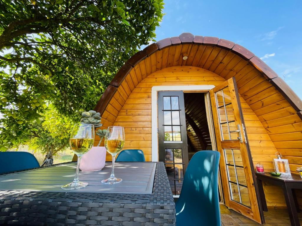 CorredouraThe Gold Pod, relax and enjoy on a Glamping house的小屋顶部一张桌子和两杯葡萄酒