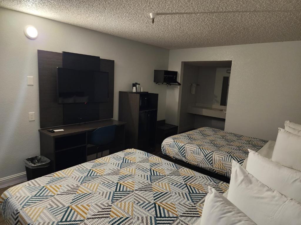 萨克拉门托Motel 6 Sacramento CA Natomas的酒店客房设有两张床和一台平面电视。