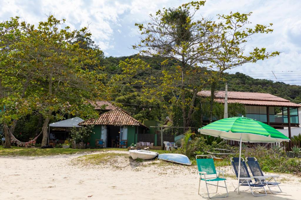 邦比尼亚斯Pé na areia, tranquilidade,conforto,2 quartos, ar-cond, Wi-Fi, pet-friendly, 7 pessoas,的海滩上摆放着几把椅子和一把遮阳伞