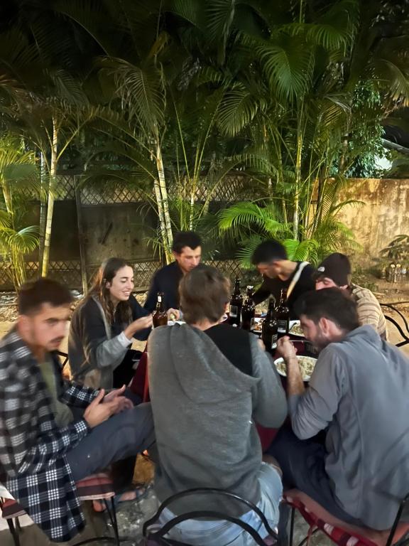 索拉哈Sauraha BnB的一群人坐在桌子旁,喝着葡萄酒