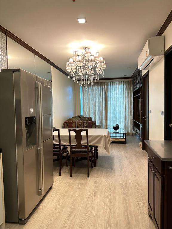 曼谷OV Residence的厨房以及带桌子和冰箱的用餐室。
