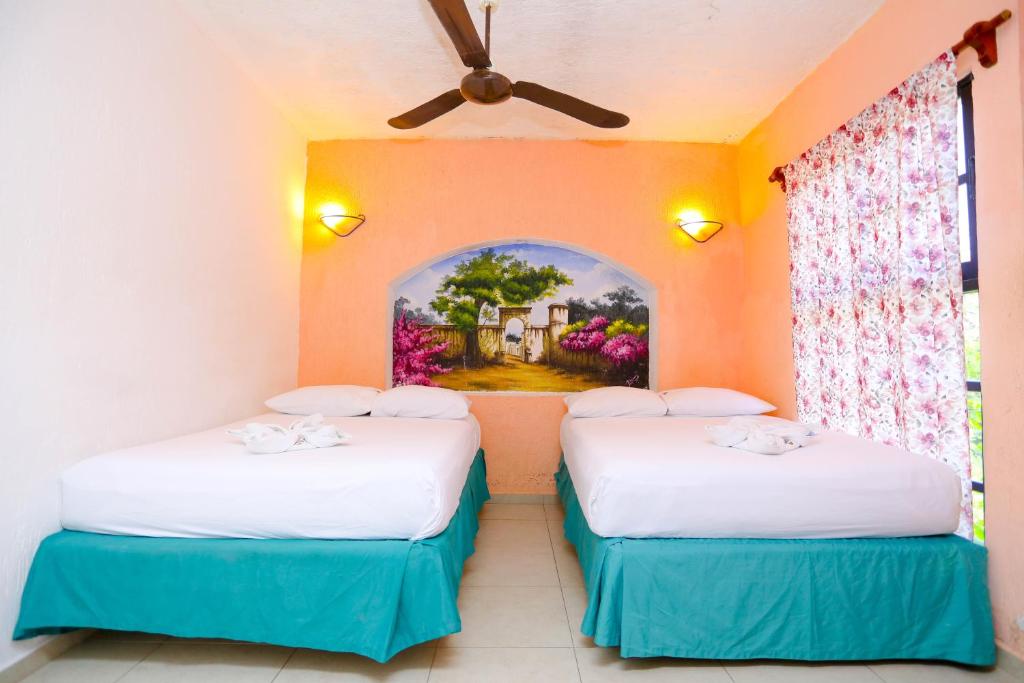 坎昆坎昆庄园酒店的墙上画画的房间里设有两张床