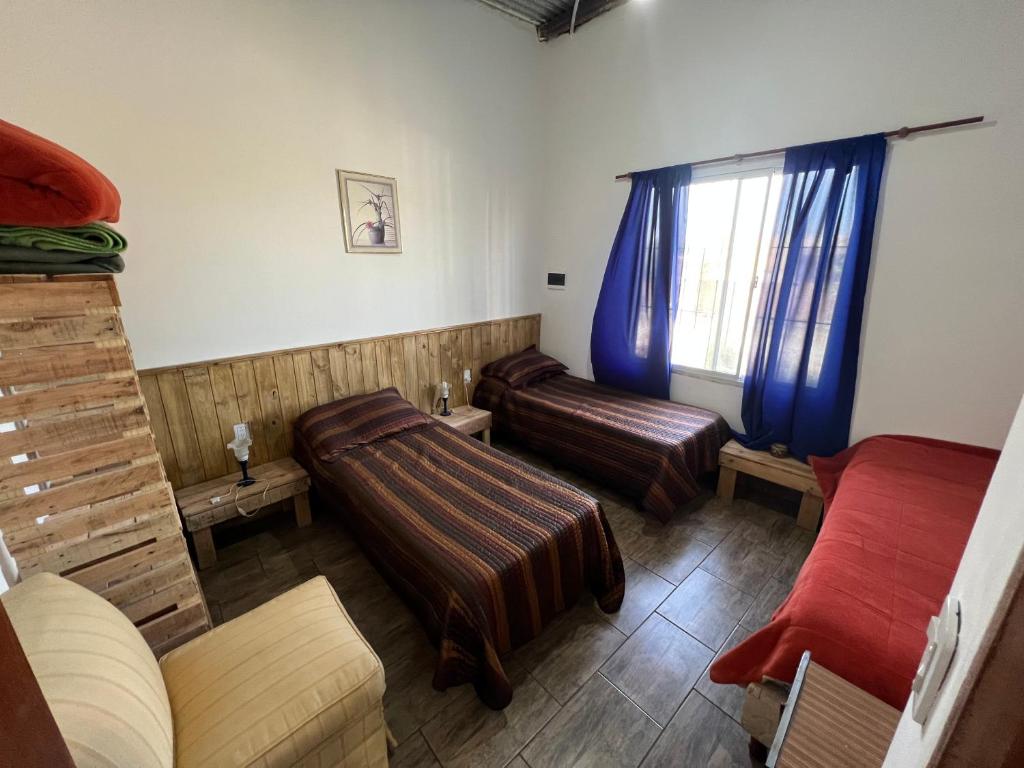 Campo QuijanoPuesta del Sol的一间带两张床和窗户的客厅
