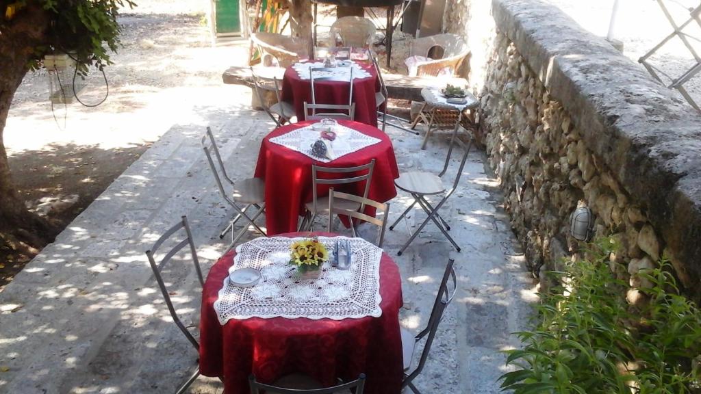 夏卡Sotto il carrubo的一组桌子和椅子,配红色桌布