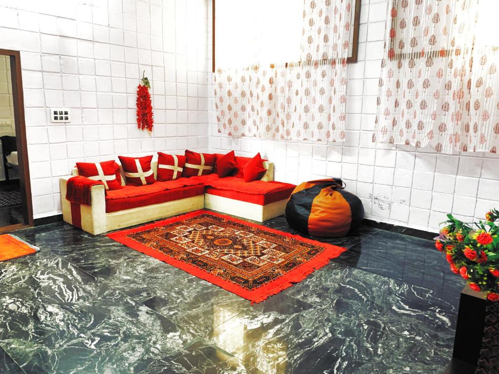 迈索尔Mannat Inn TS Mysore - Premium Homestay的客厅设有红色沙发和大理石地板