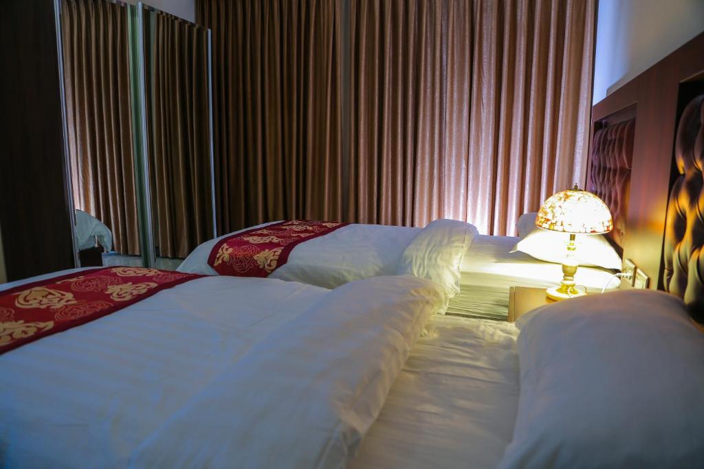 安曼Qaser Al-Sultan Hotel Suites的酒店客房,设有两张床和一盏灯