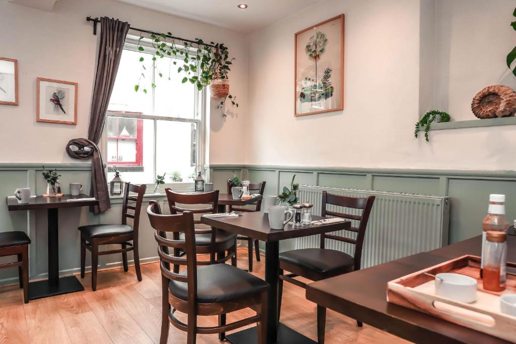 斯泰兹Endeavour, Staithes的一间带桌椅的用餐室和窗户。